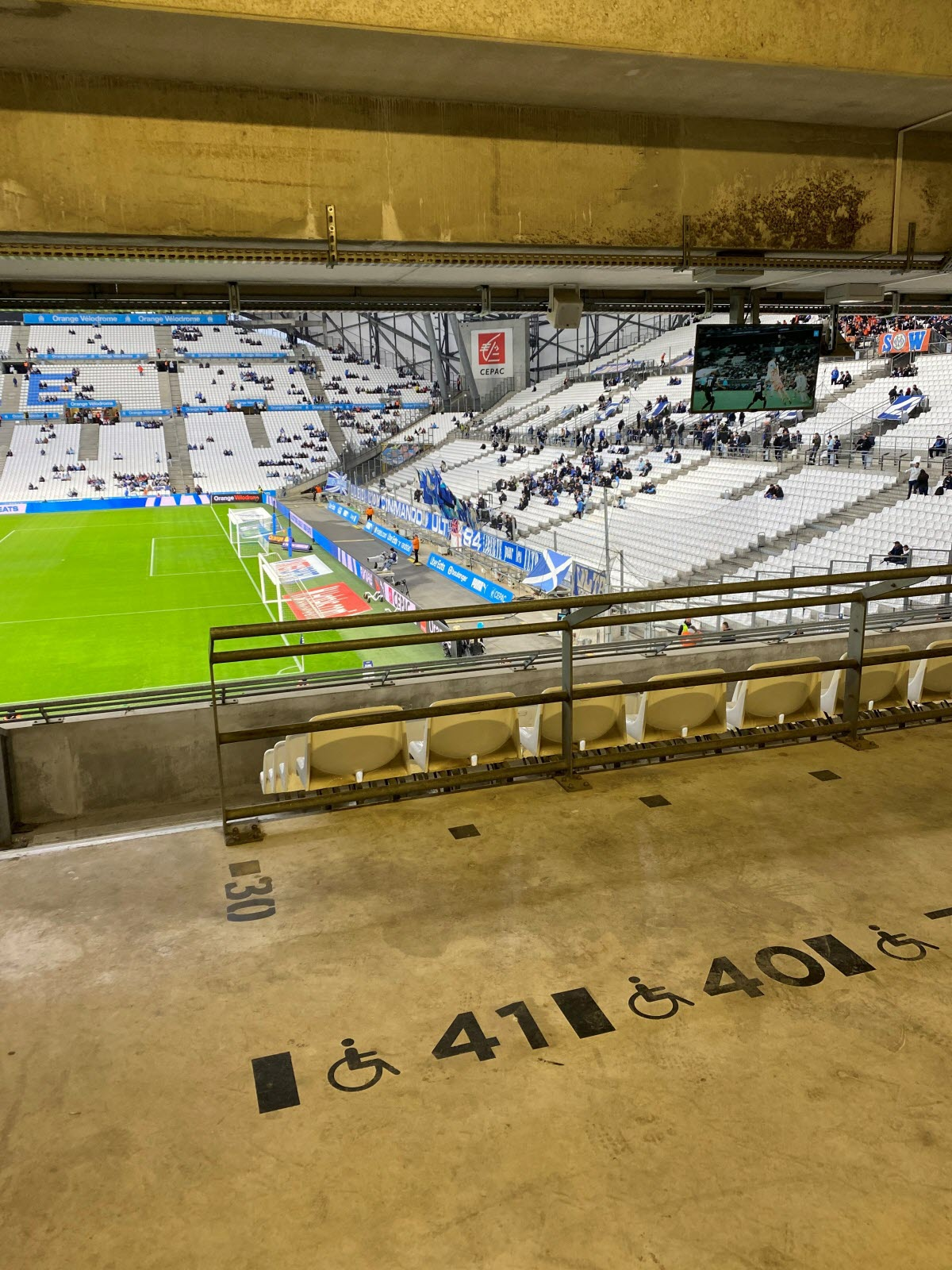 Emplacements PMR du Vélodrome avec marquages fauteuil roulant et vue sur le terrain